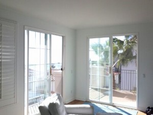 pair of sliding glass doors with manual drop roll shades