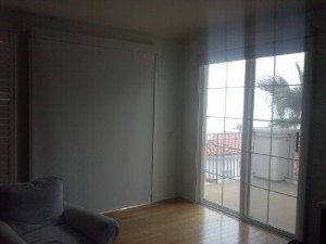 pair of sliding glass doors with manual drop roll shades