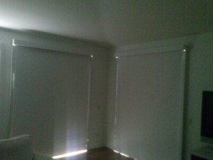 pair of sliding glass doors with manual drop roll shades