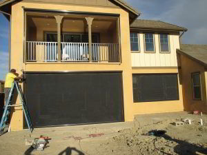 Motorized Power Screens with black solar screen and brown aluminum housing